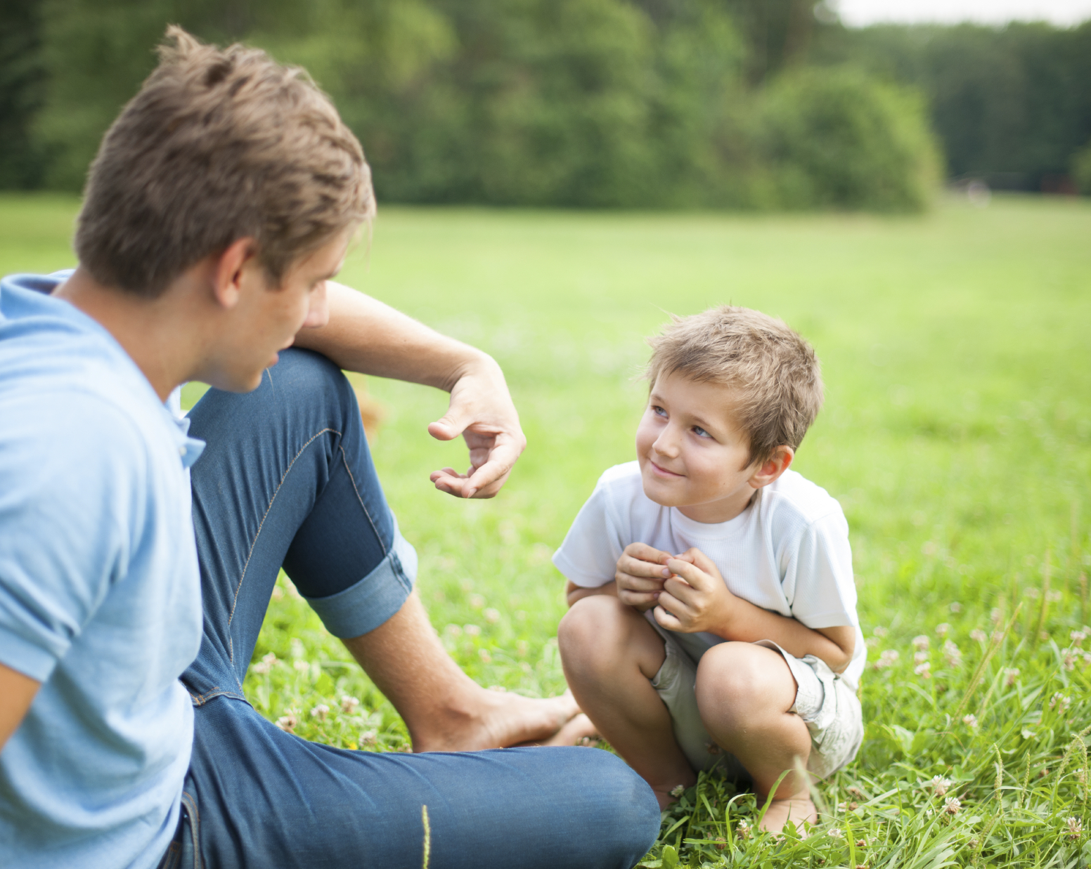 Father and son talking in park