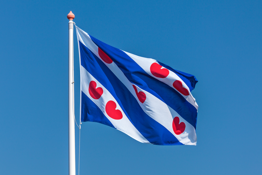 Dutch flag of the province Friesland against a clear blue sky